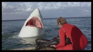 Escena de Aquel último tiburón con el tiburón emergiendo junto a una lancha